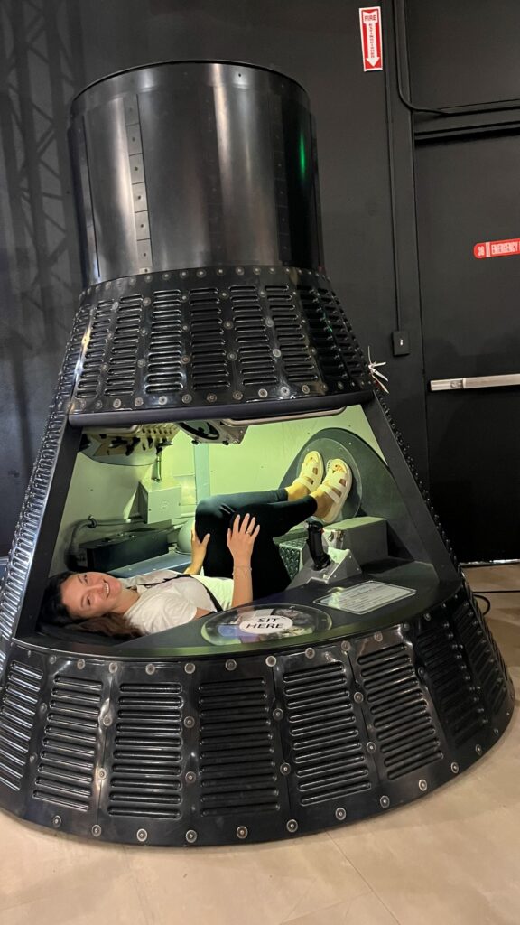 Woman sitting in rocket ship model at air and space museum san diego at balboa park.